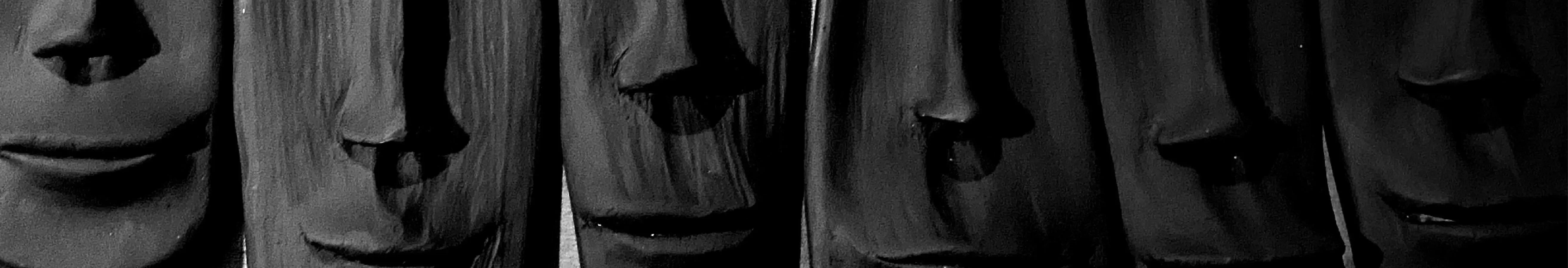 Black sculpted faces in a row, modern handcrafted Pakistani art decor