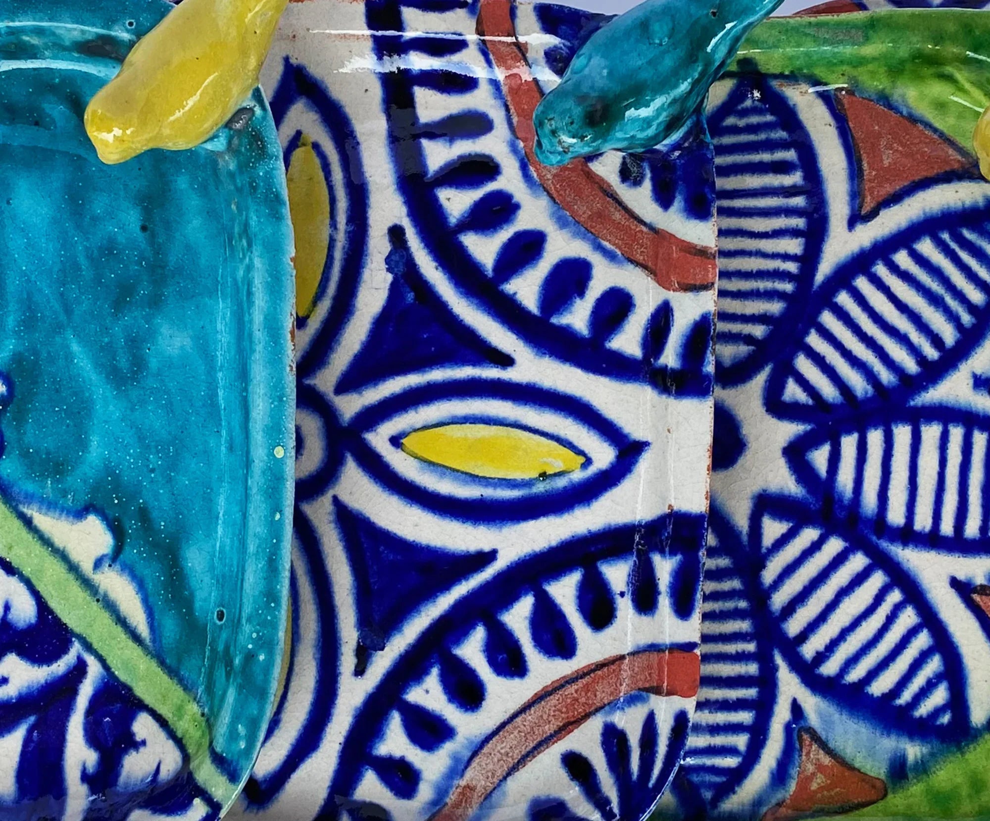 Handcrafted ceramic plate with vibrant blue floral and geometric patterns, yellow and turquoise accents