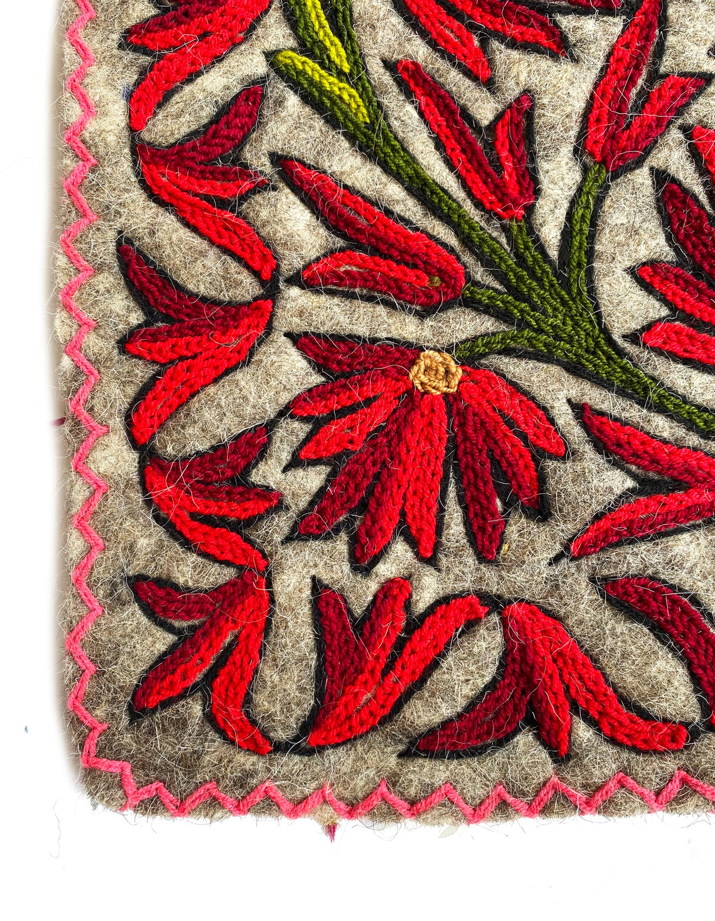 Embroidered fabric with red floral pattern on a beige background